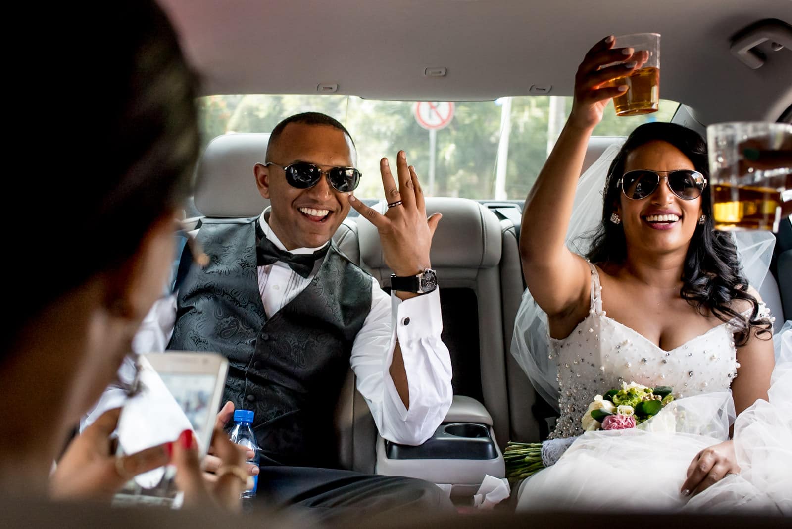 Ethiopian bride and groom drinking Johnny Walker Black whisky in a limo in Addis