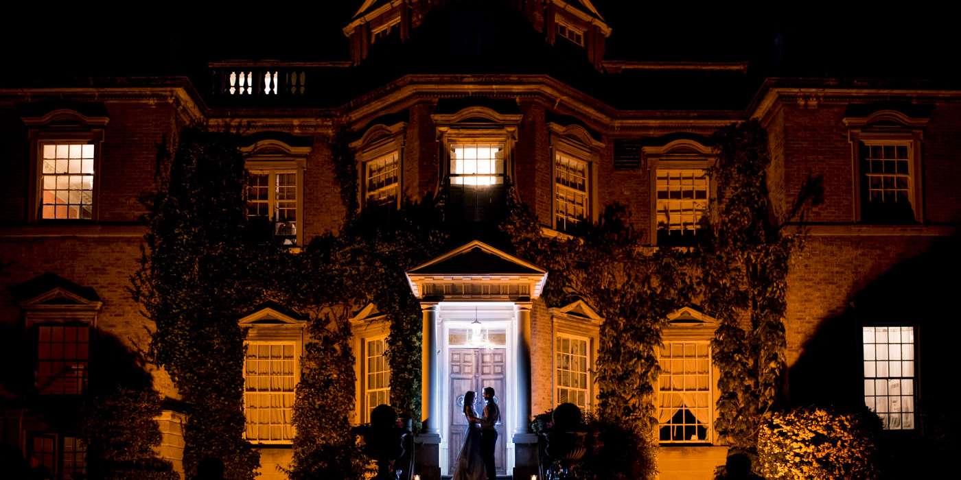 creative flash portrait of bride and groom outside Hampton Court house at night