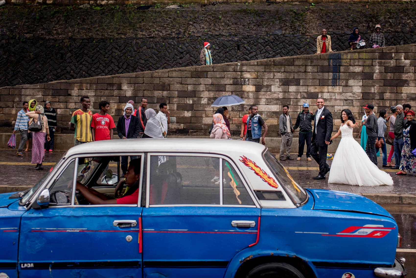 Ethiopian wedding couple having portraits in Rush hour in Addis Ababa (Ethiopia) with a blue taxi