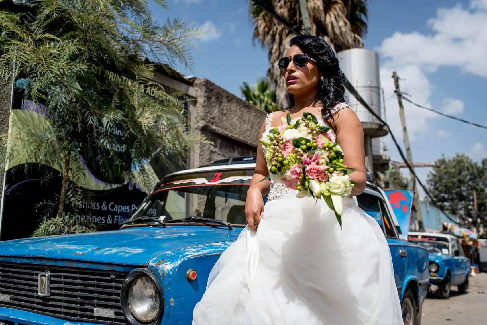 Wedding bride in Addis Ababa in front of a blue Landa taxi