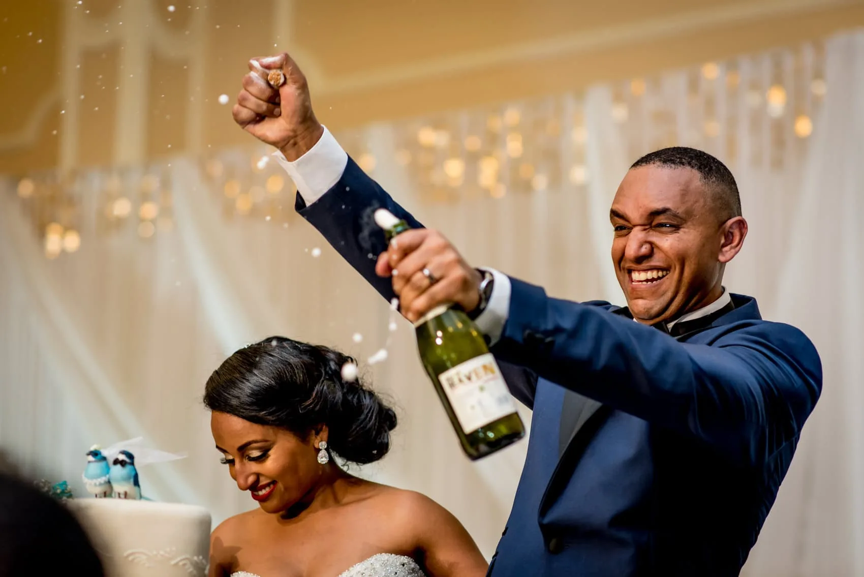 groom pulling cork off a bottle of wine
