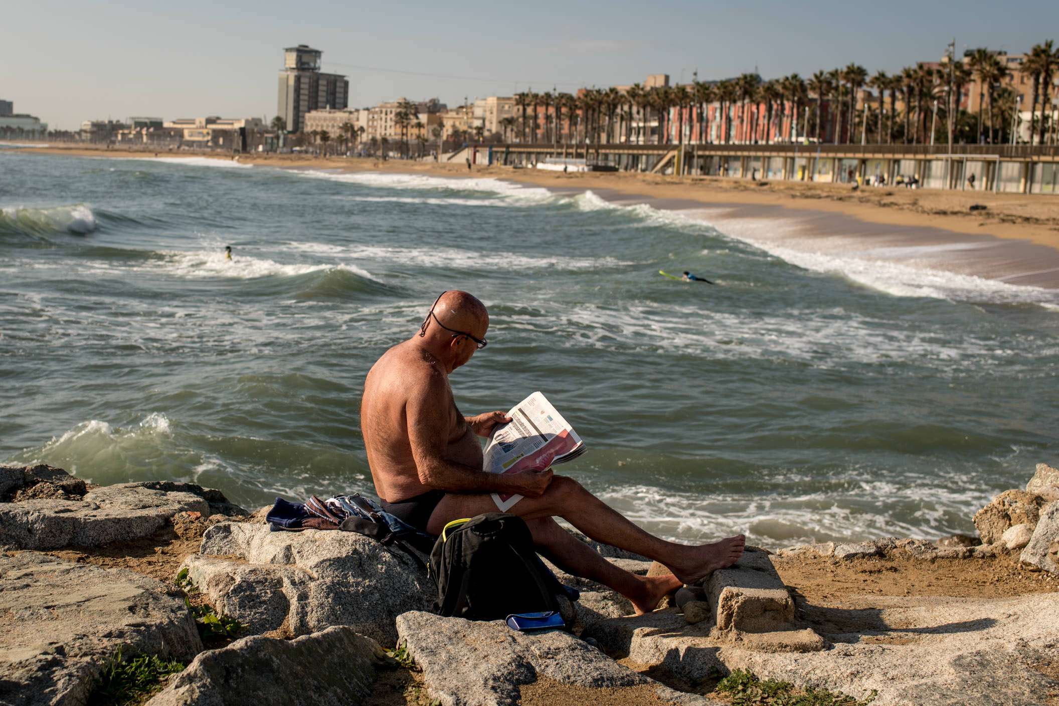 man reading newspaper on the beach in Barcelona for some Barcelona street photography