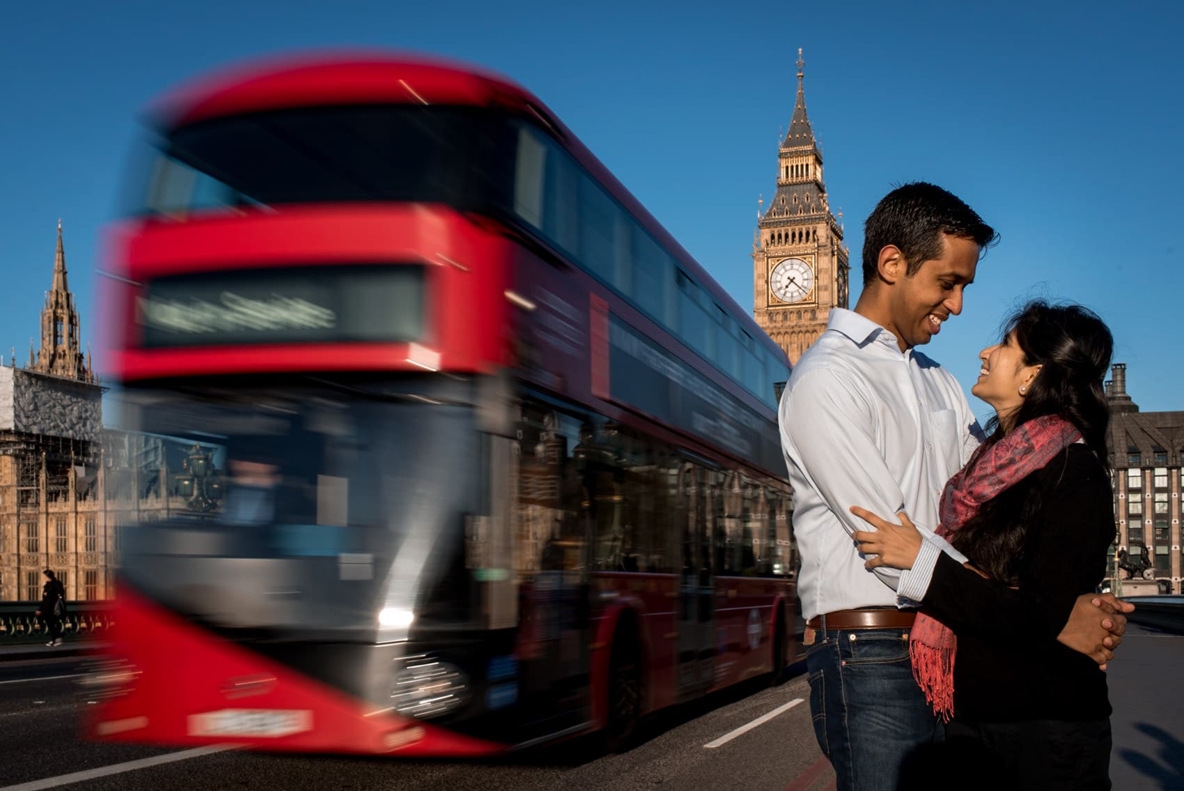 Photo of a couple during their london engagement photo shoot outside of Big Ben with a red double decker bus