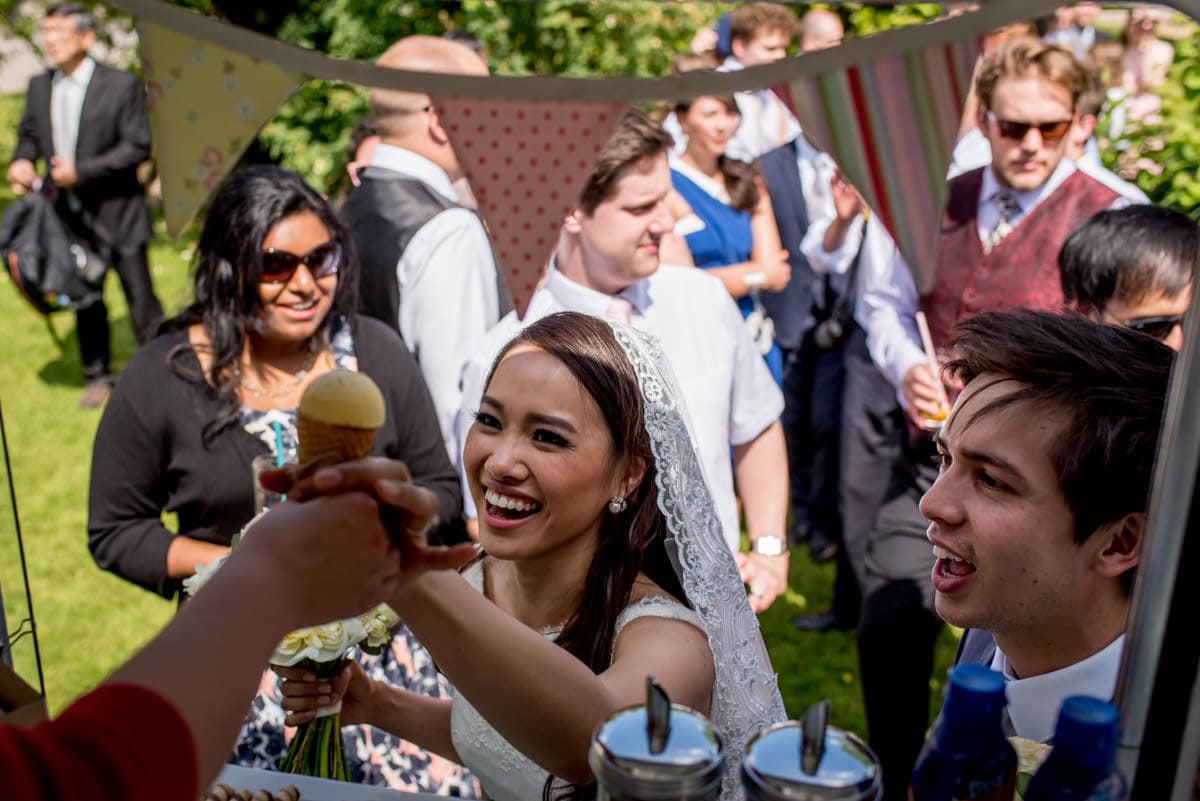 bride being given ice cream from the ice cream van at her summer wedding