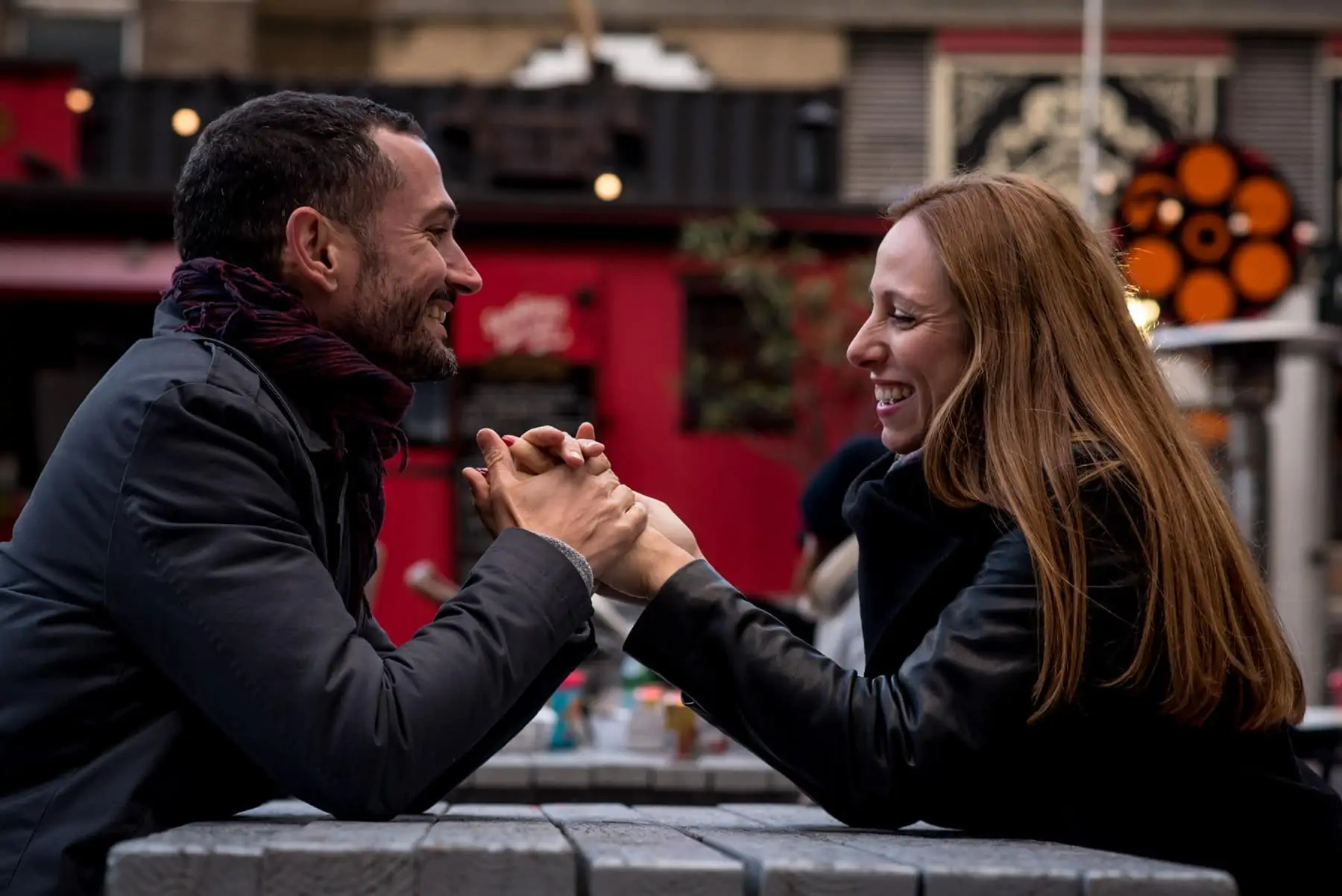 Photo of a couple holding their hands and laughing in Shoreditch, London