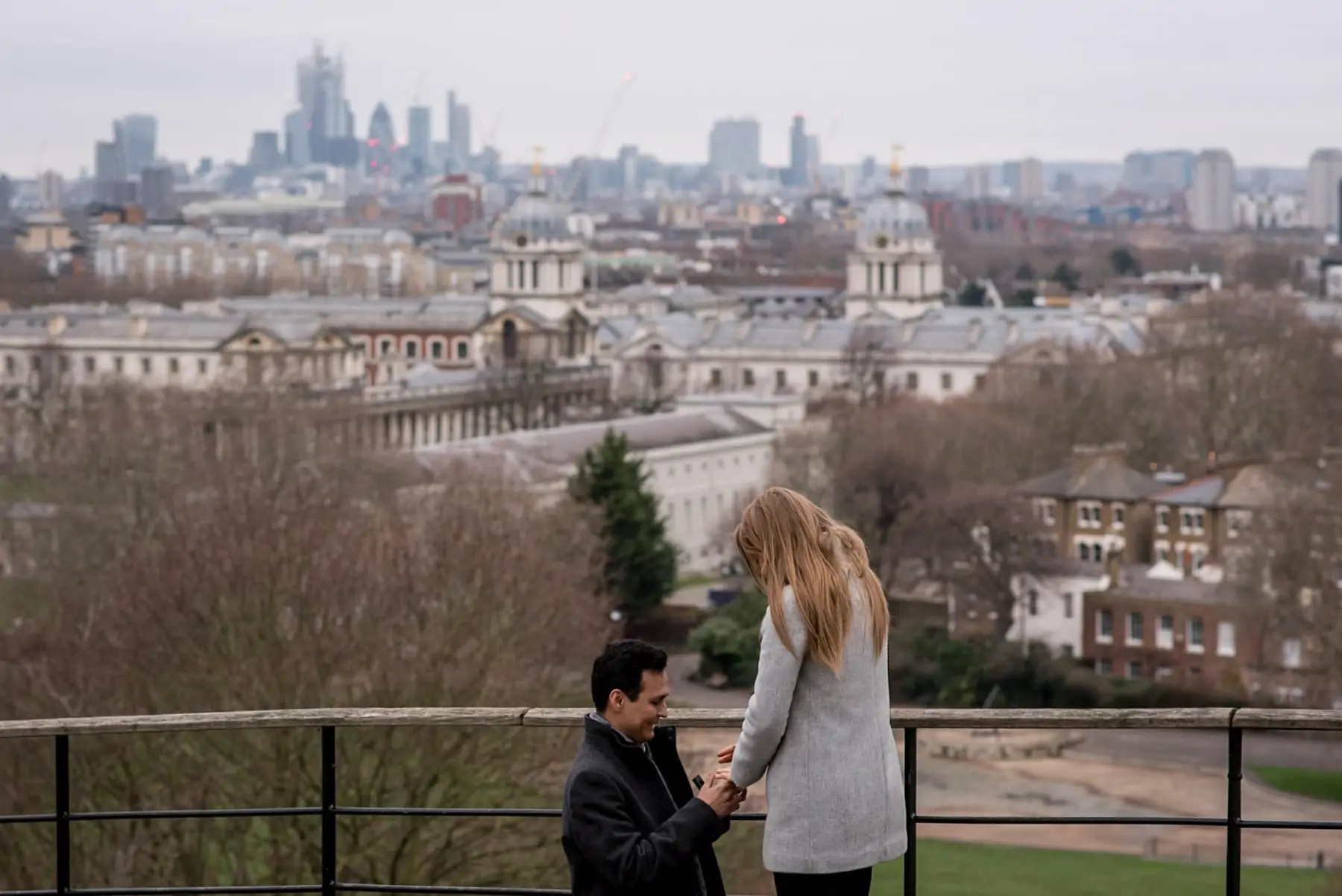 A man proposing to his girlfriend in Greenwich park with views over London