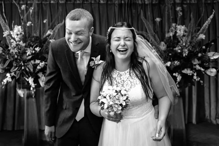 Black and white photo by london wedding photographer of couple laughing