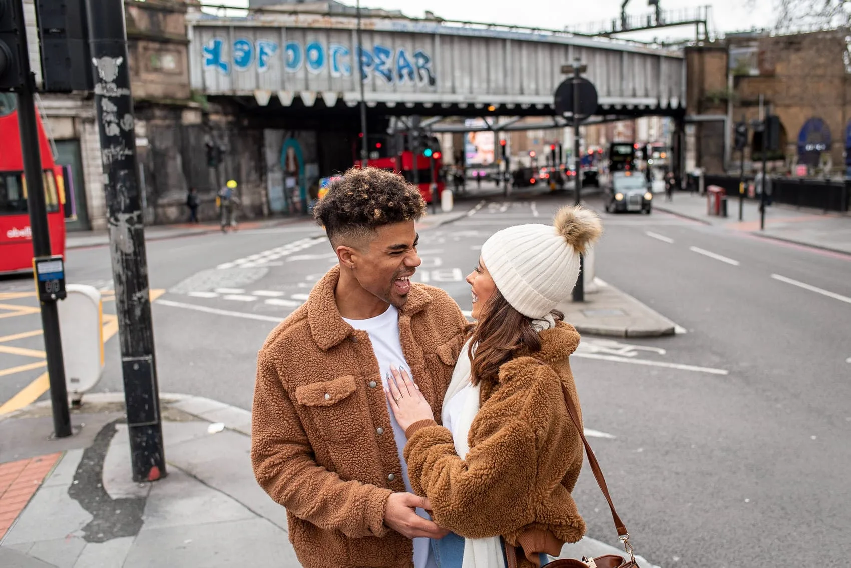 Couple laughing on their London engagement shoot