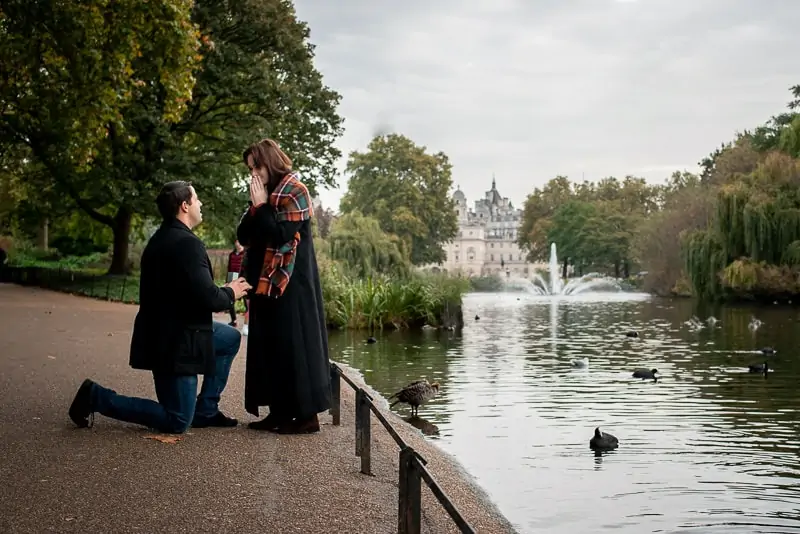 Photo of man proposing to his girlfriend next to the lake in St James Park, London