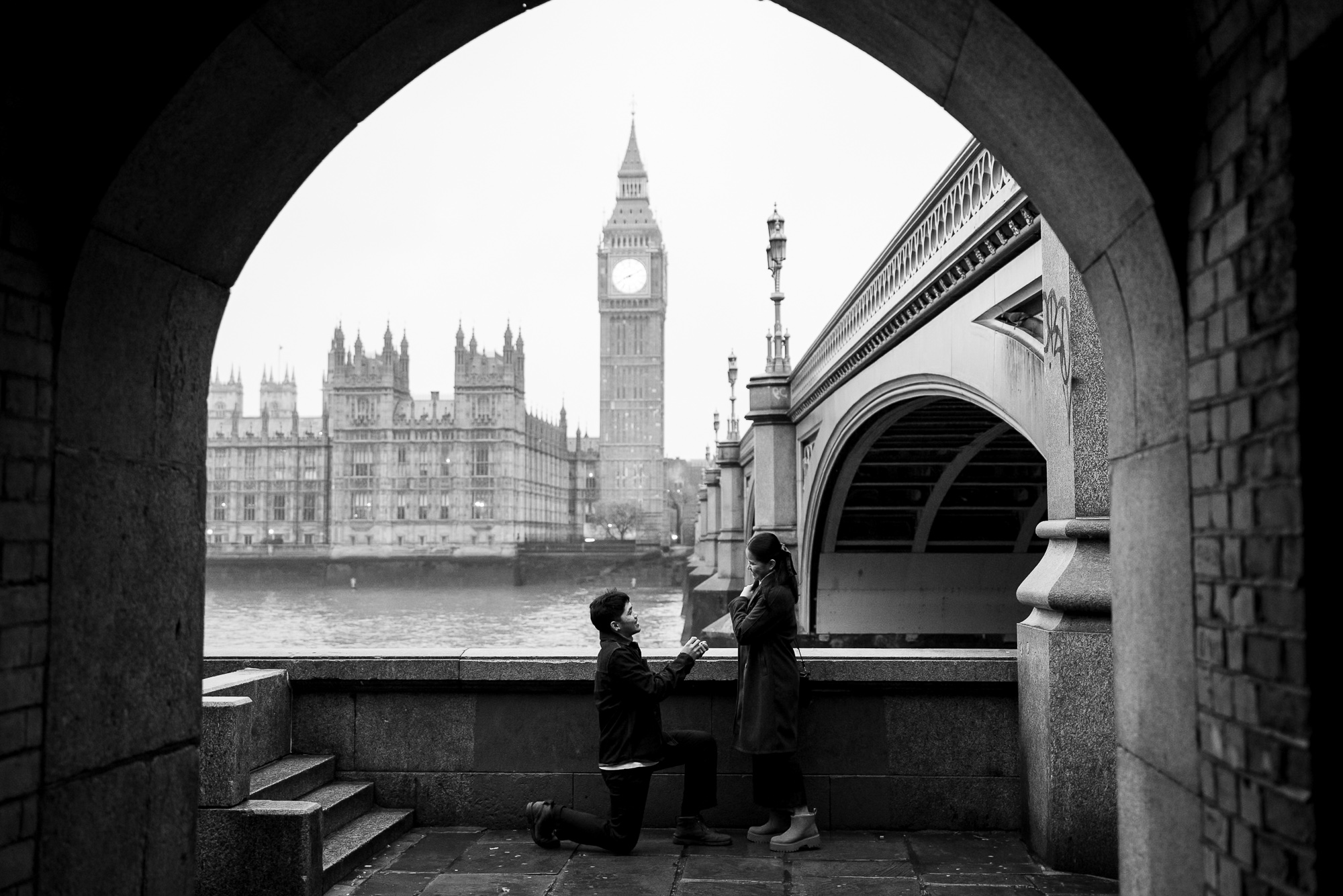 a man proposes to his girlfriend in front of Big Ben on a winters mornings