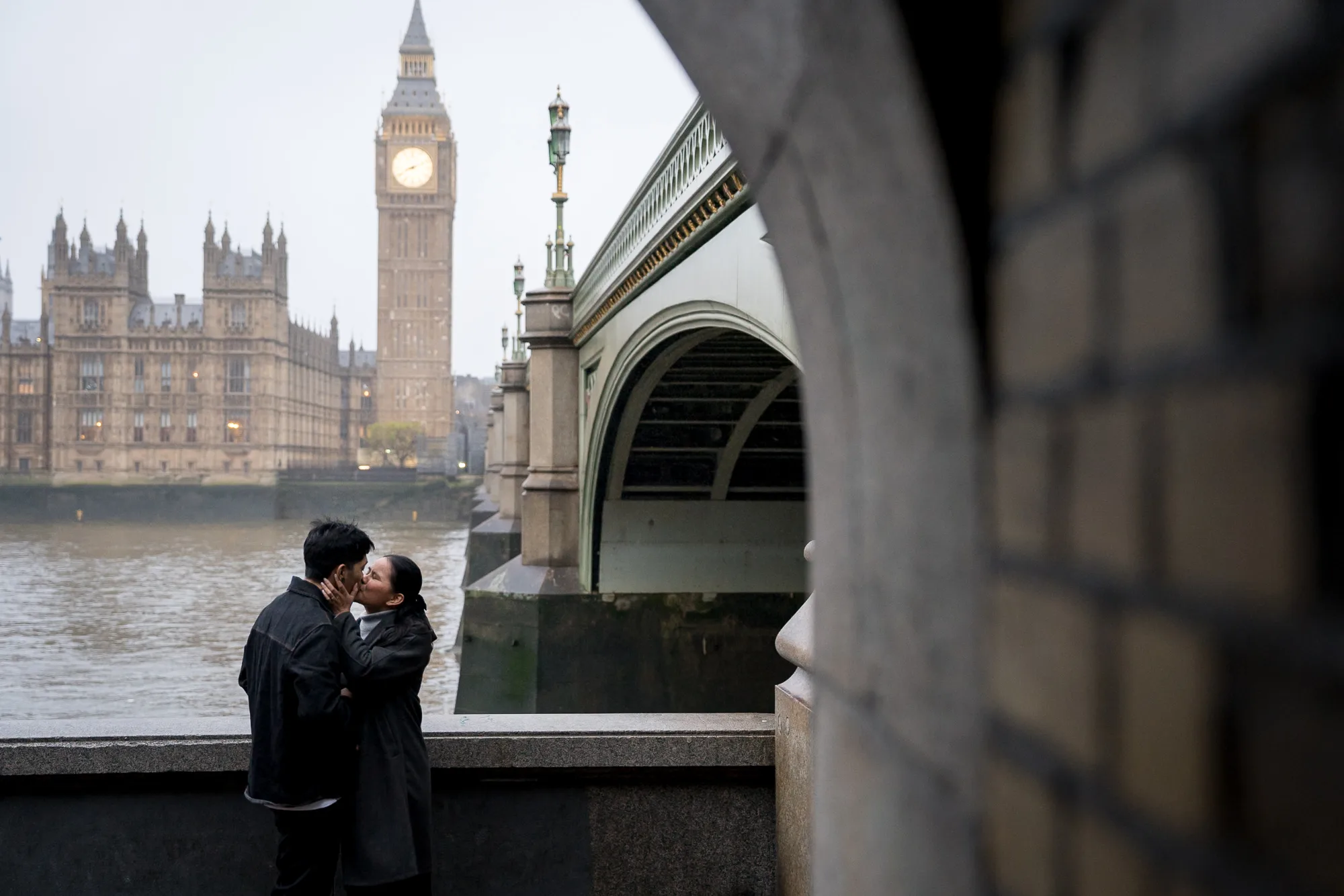A couple share a kiss in front of Big Ben on a winter's morning during their London proposal shoot