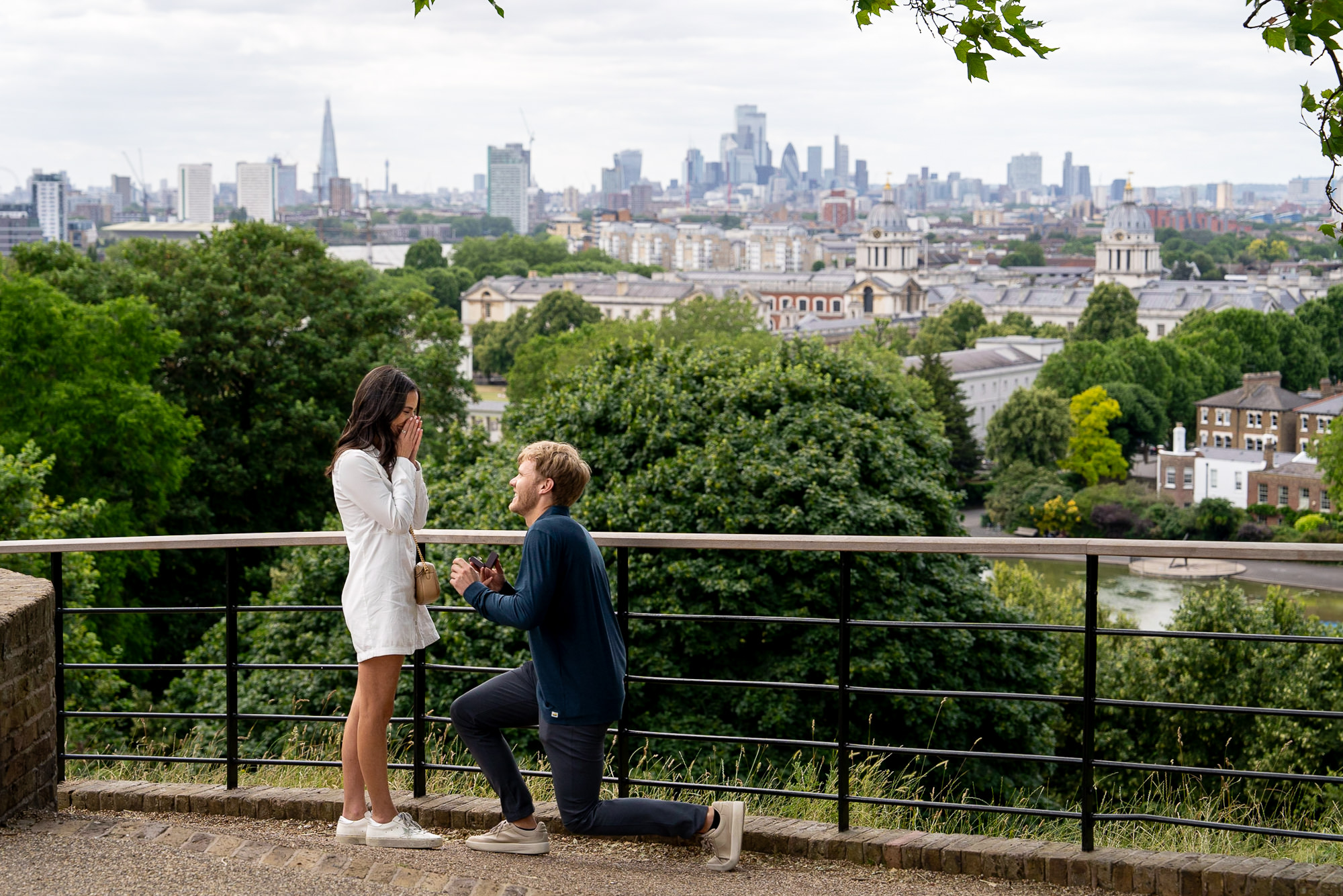 A romantic proposal taking place at One Tree Hill Vista Point in Greenwich park with views over London