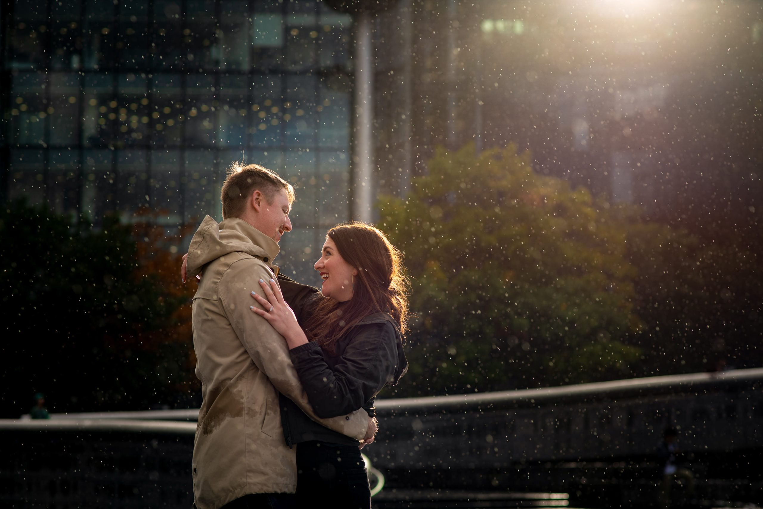Couple hugging in the rain during their London proposal photoshoot