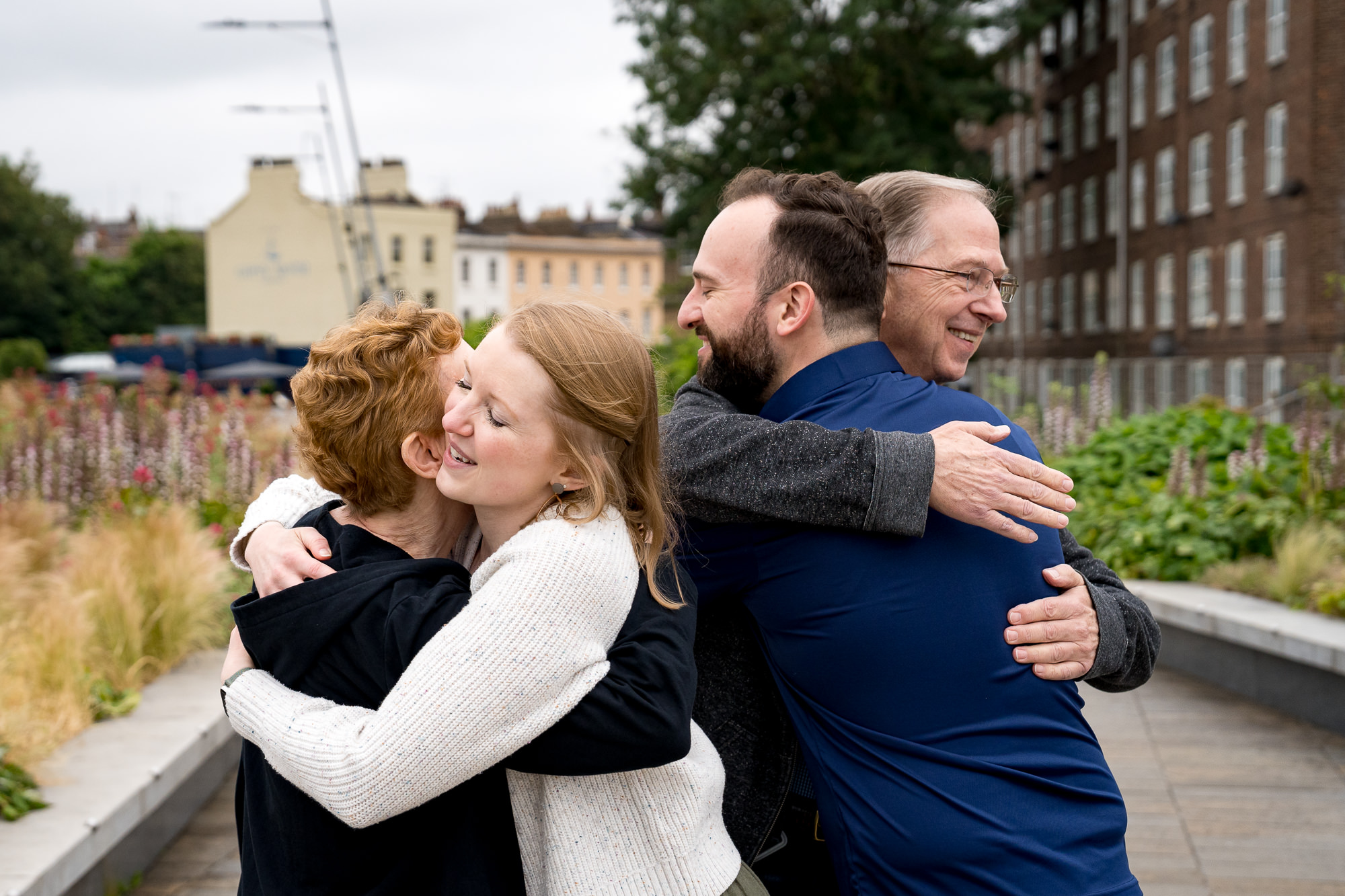 parents embrace their daughter and her new fiancé after they got engaged in Greenwich, London