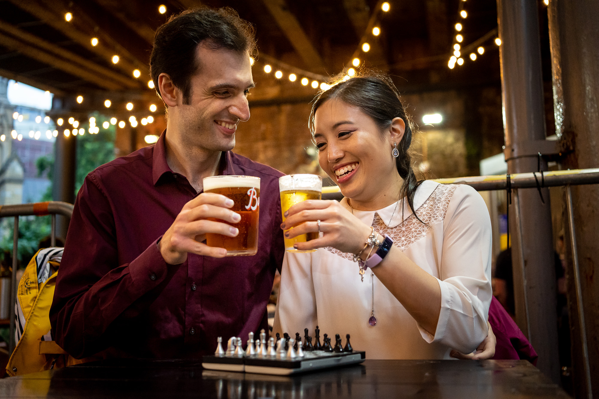 a couple playing chess in the pub after getting engaged in London
