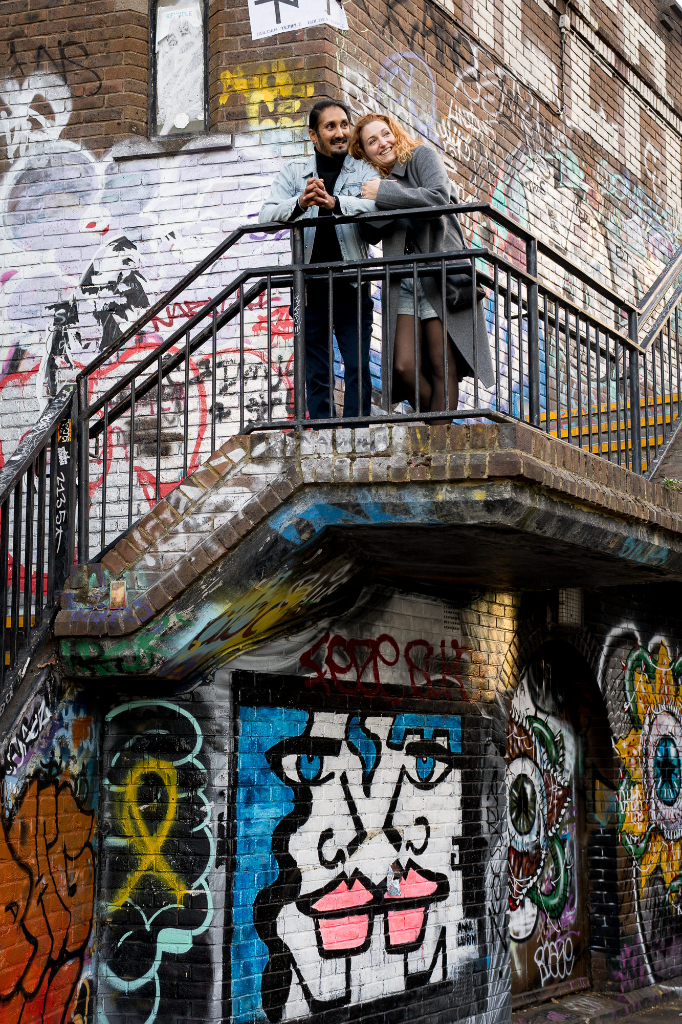 a couple standing next to graffiti along Camden canal
