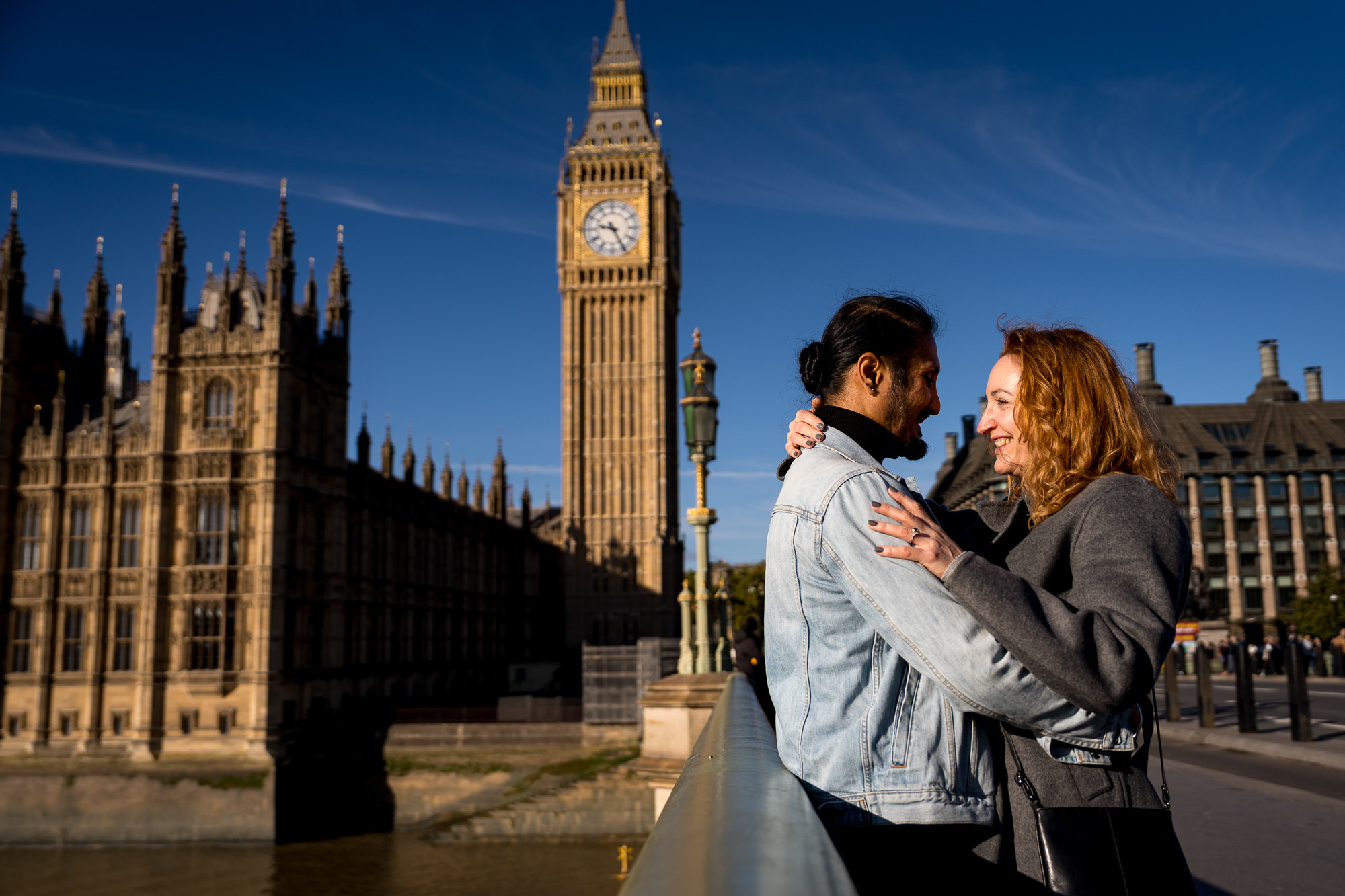 a recently engaged couple hugging in front of big ben on a sunny day during their London proposal shoot