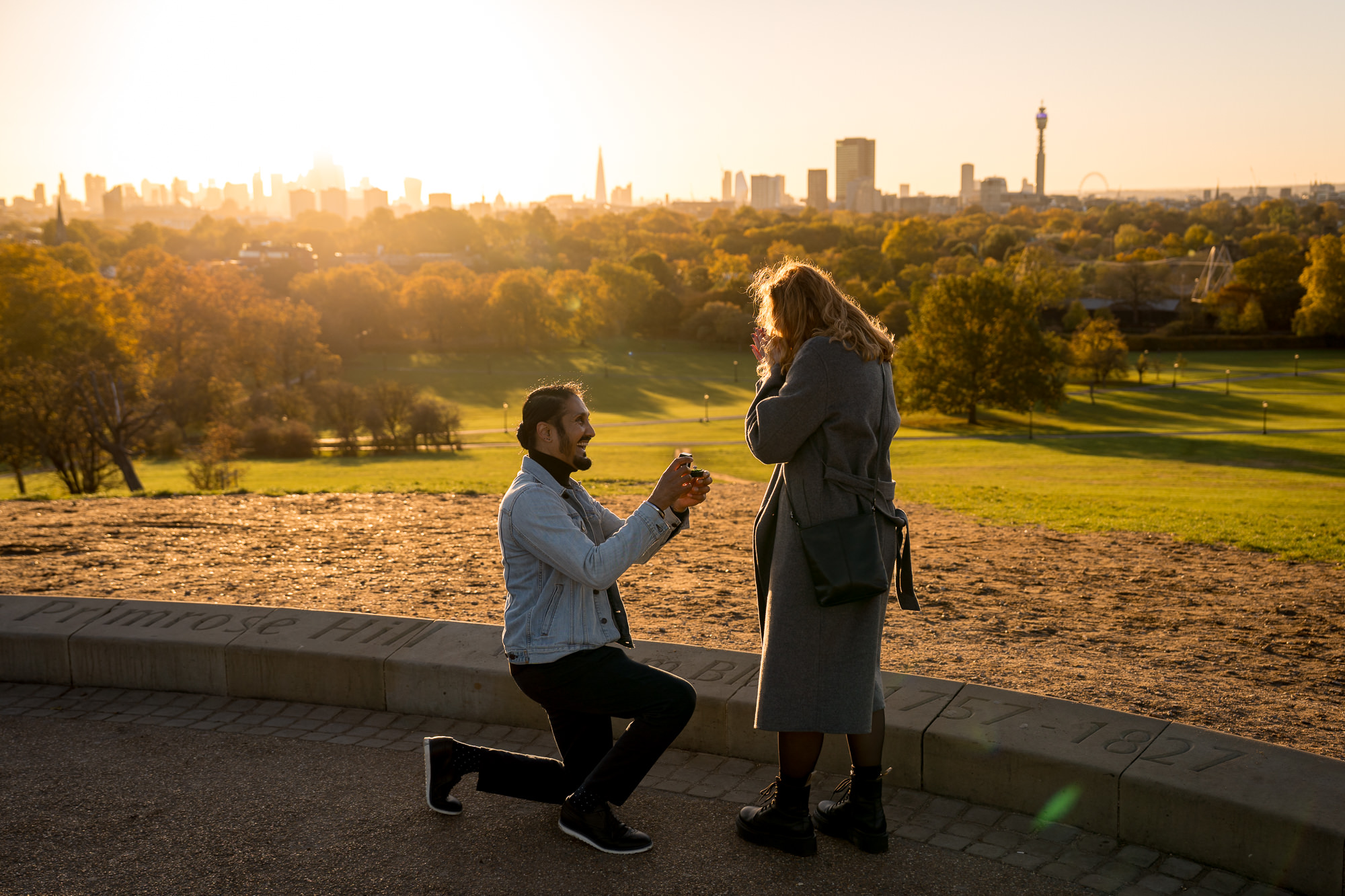 A couple proposing on top of the primrose hill viewpoint at sunrise in London