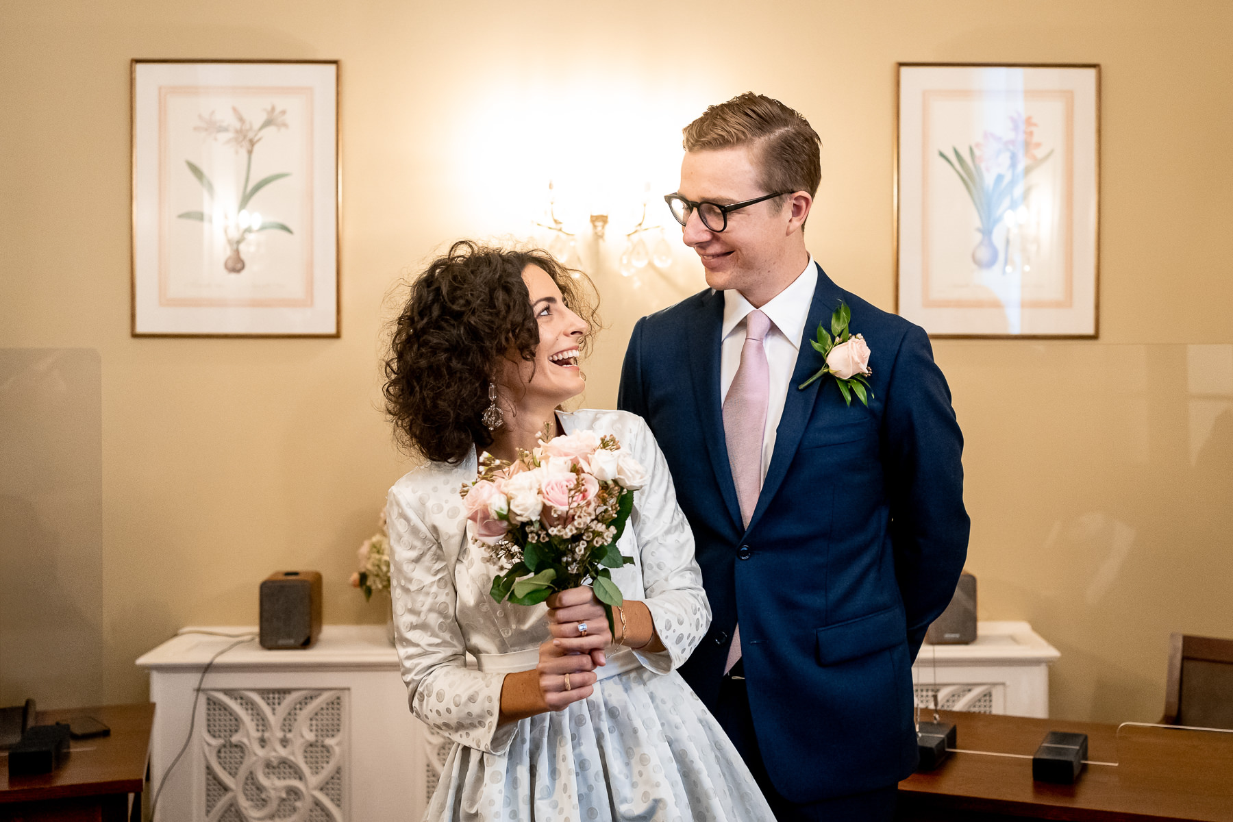 A couple laughing together at the end of their ceremony at the Chelsea Old Town Hall in London